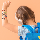 Child with temporary tattoos of monster trucks on an orange background